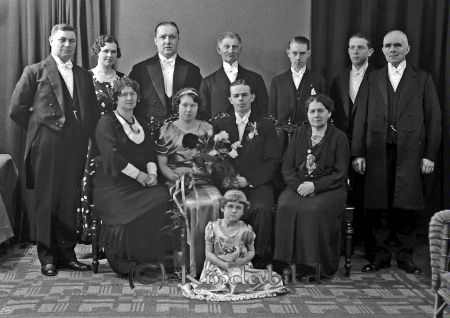 Målare Gilbert Kisa
raja
Brudpar med en tärna, även tre vuxna kvinnor och sex vuxna män.
Målare Gilbert  

raja
Brudparet är Sven och Gudrun Gilbert.
 Rad nr 2 , nr 2 från höger Kalle Gilbert och nr 3 är Bror, bror till Gudrun.
 Till vänster brudens far. Han arbetade vid järnvägen och byggde hus på andra sidan järnvägen i riktning mot Mjellerum.
 Källa: Studiegruppen hembygdsgården 
Nyckelord: Gilbert Kisa