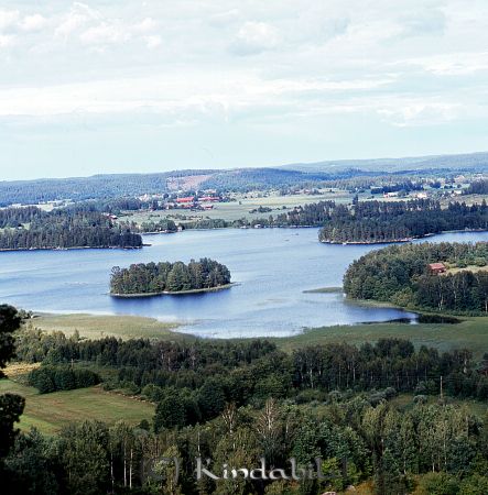 Kindavyer
raja
Vy över en sjö med gårdar och hagmark på motsatta sida
