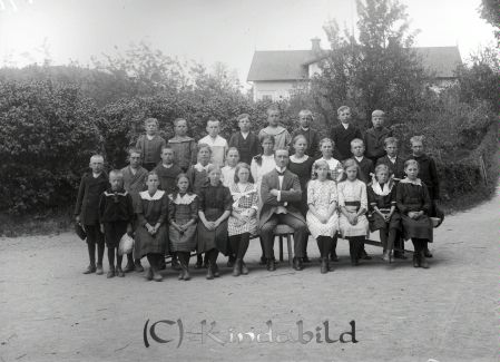 Grupporträtt Skolklass med 28 elever och en lärare
godj
Grupporträtt Skolklass med 28 elever och en lärare
Framför skolan i V Eneby

raja
Läraren är Josef August Emanuel Rüdeberg född 1885 i �?stra Korsberga. Jönköpings län. Kom till Västra Eneby 1913 och flyttade till Väckelsång i Kronobergs län 1922-08-19.
Kantor Larsson efterträdde honom som lärare och kantor.
Källa: Kyrkoarkiv Västra Eneby. 
Källa: Gerd Pettersson 

Nyckelord: Grupporträtt Skolklass