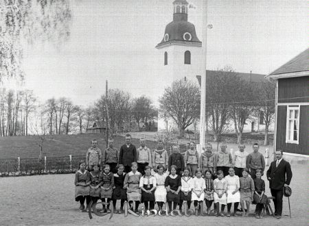 Skolklass med tjugosex elever och en lärare i Norra Vi
godj
Skolklass med tjugosex elever (elva pojkar och femton flickor) och en lärare på en bänk framför Kyrkskolan och Kyrkan i Norra Vi
Nyckelord: Skolklass Norra Vi