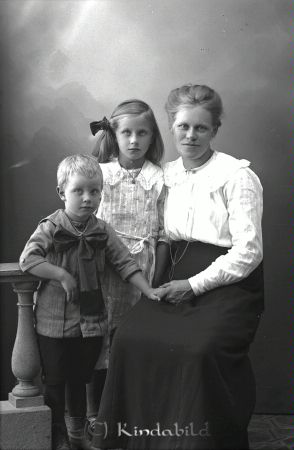 Anna Andersson Kjusebo  Ulrika
godj
Anna Andersson Kjusebo  Ulrika
Grupporträtt med en kvinna och två barn

raja
Anna Charlotta Andersson född Farman med barnen Vega Miriam Laura född 1914 och Karl Ivar Tage född 1917 i Kisa.
Anna Charlotta var änka efter Karl Otto Andersson.
Omgift 1923 med Emil Teodor Jonsson från Tystberga.
Sonen Tage bosatte sig i Lomgölen Kottebo.
Källa: Kyrkoarkiv Kisa 
Källa: Gerd Pettersson

Nyckelord: Andersson Kjusebo