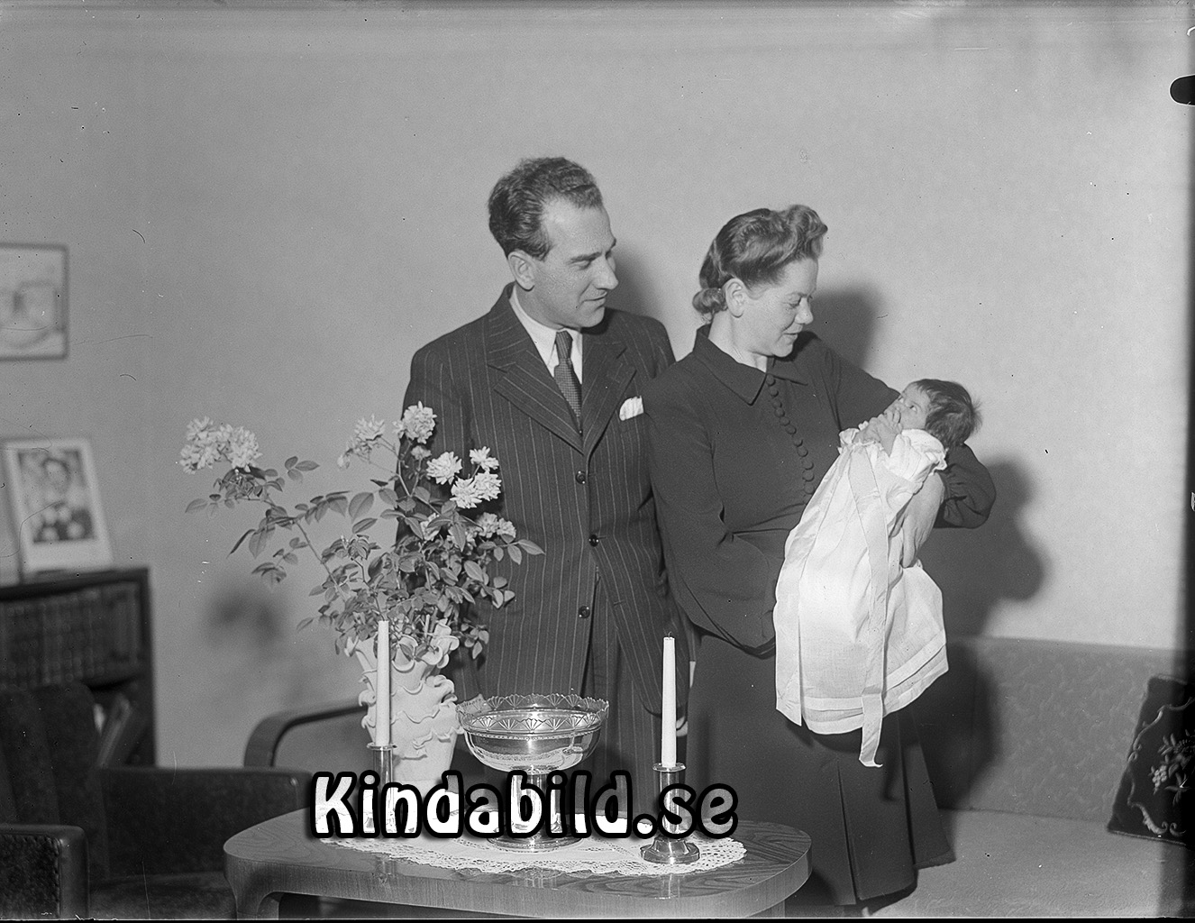 Familjen Magnusson Kisa
raja
Man o kvinna som håller ett litet barn i famnen 

LaSa 20231219: Martin och Karin Magnusson. Martin föreståndare på Sandströms Kläder. 
Det borde vara deras son Magnus som döps.

Nyckelord: Magnusson Kisa