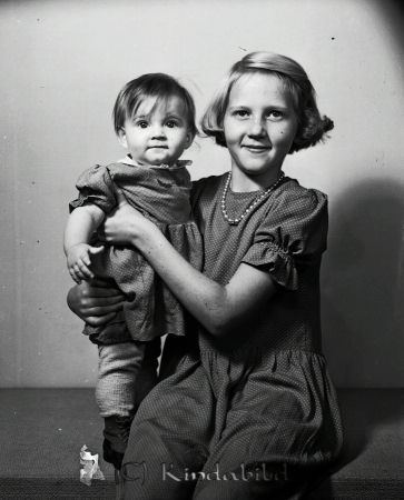 Arvidsson Lisbeth och Barbro Näs Svalsjö
raja
En blond flicka med håret kammat åt sidan bär en mörk kortärmad klänning med vita prickar. Håller en yngre flicka i famnen.

raja
Flickorna är systrar och bodde i Näs.
Föräldrarna var Arvid och Alice Karlsson i Näs. Barbro född 1943 i Kisa. Gift 1973 med Bengt Johansson från Hofors. Bor 1990 i Vollsjö.
 Lisbeth född 1933 bodde 1950 i Kimstad och arbetade som affärsbiträde. 1955 gift med Karl Åke Holm. Bodde i Linköping 1990.
 Källa: Folkräkning 1950 och 1990 
Källa: Studiegruppen hembygdsgården 
Nyckelord: Arvidsson Svalsjö