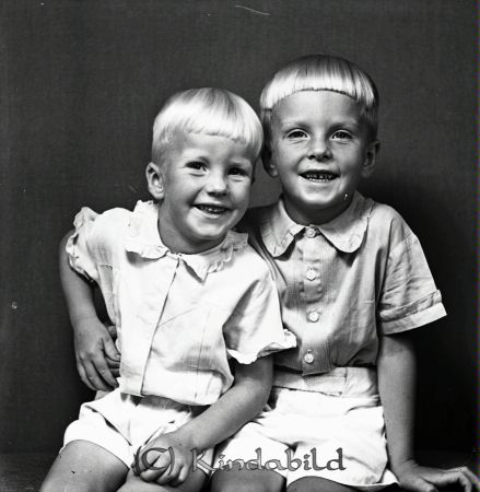 Börje och Lars-Olov Nyberg Kisa
gepe
Två som ljushåriga pojkar i ljusa kostymer

raja
Pojkarna är söner till åkare Bertil och Vasti Nyberg. Börje var född 1939 i Kisa.
 Det fanns två barn till i familjen Britta född 1933 och Sven-Olof.
 Familjen bodde i fastigheten Broddhaga på Linnégatan i Kisa.
 Sonen Lars-Olof var dykare och var med i bärgningen av Wasaskeppet.
 Källa: Studiegruppen hembygdsgården 
Nyckelord: Nyberg Kisa