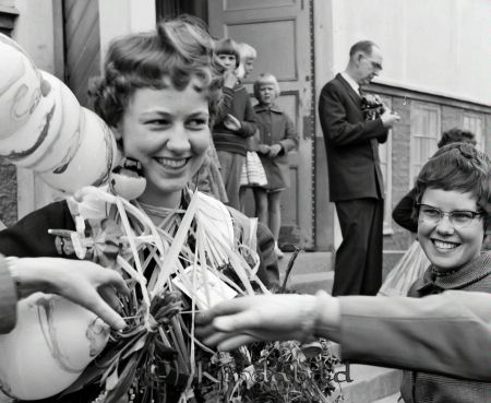 Realexamen Kisa
raja
En kvinna som bär ljus klänning har blommor och ballonger runt halsen. 
amwa
Marianne Andersson
Nyckelord: Kisa