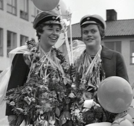 Realexamen Kisa Skola
raja
Två kvinnliga studenter med blommor och ballonger runt sina halsar. 

raja
Fr vänster Ragna Larsson och Ing-marie Modigh.
Källa: Studiegruppen hembygdsgården 
Nyckelord: Skola Kisa
