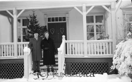 Kyrkoherde Myrgård
raja
Vinterbild på en man och kvinna som står i en trappa upp till ett hus 
Nyckelord: Myrgård