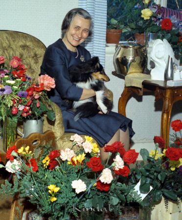 Fru Jana Holmberger Axhult Kisa
raja
Foto med en kvinna omgiven av blommor och med en hund i knät 
Nyckelord: Holmberger Kisa