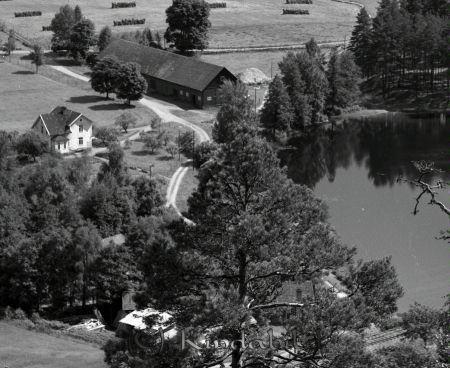 Kindavyer
raja
Bild över en gård som ligger bredvid en sjö omgiven av åkrar
