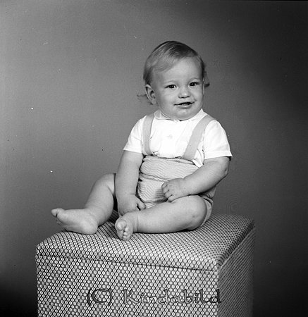 Bertil Nordenberg Kisahus E Kisa
gepe
Liten pojke klädd i kortbyxor och vit kortärmad tröja sitter på en klädd pall.
Bertils far var kommunalkamrer på Kinda kommun.
Nyckelord: Nordenberg Kisa