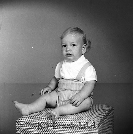 Bertil Nordenberg Kisahus E Kisa
gepe
Liten pojke klädd i kortbyxor och vit kortärmad tröja sitter på en klädd pall.
Bertils far var kommunalkamrer på Kinda kommun.
Nyckelord: Nordenberg Kisa
