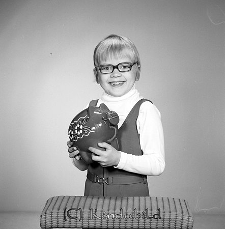 Anette Hjelte Gamla Eksjövägen 16 A Kisa
raja
Flicka klädd i ljus tröja med hög krage som håller i en spargris  

Nyckelord: Hjelte Kisa