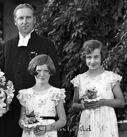 Kyrkoherde Myrgård Kisa
raja 
Brudgummen och två brudtärnor         

raja
Tärnor fr vänster Eva Tidman och Anna-Beth Bergman, syskonbarn till bruden.
 Eva Tidman dotter till brudens syster Ebba gift Tidman och flickorna Bergman var döttrar till brudens syster Karin gift Bergman.
 Källa: Studiegruppen Kisa hembygdsgård 
Nyckelord: Myrgård Kisa