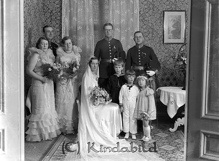 Karl Gustav Högberg Sundbyberg
raja 
Brudpar med vittnen och brudtärnor  

raja
Underlöjtnant i reserven Carl Gustaf Högberg Sundbyberg född 1908 och Carin Siri Augusta Crabbe född 1910 från Granliden under Karleby. De vigdes i Kisa 1 april 1934. Tärnan närmast vänster om bruden kan vara Curt Wachenfeldt syster.
Källa: SVAR 
Källa: Studiegruppen hembygdsgården

raja
Carin Siri Augusta var dotter till Vice häradshövdingen och f d kronofogden Hugo Peter Vilhelm Petersén född 1864 i Fjälkinge och Hanna Augusta född Crabbe 1878 i Kristianstad.
Källa: Folkräkning 1860-1947 
Källa: Gerd Pettersson

Nyckelord: Högberg Sundbyberg